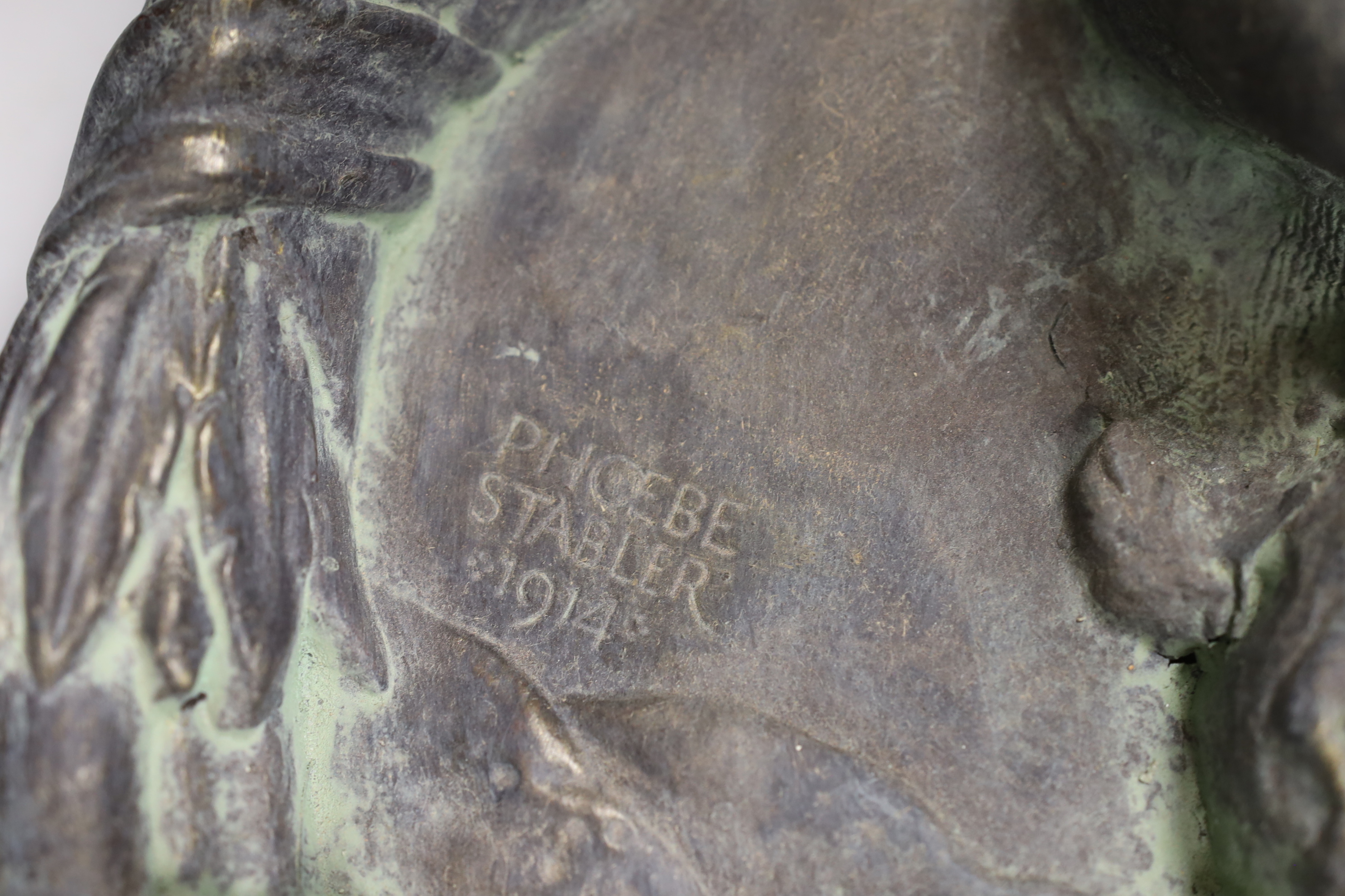 Phoebe Stabler (1879-1955). 'The Piping Faun', a patinated copper covered plaster roundel plaque, signed and dated 1914, cast in relief with a central faun framed by a decorative garland border, 44cm x 42cm